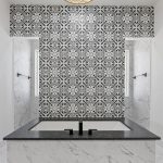 Modern bathroom with a black-and-white patterned tile accent wall, freestanding black soaking tub with matching fixtures, marble floors and walls, and white cabinetry on both sides.