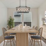 A modern dining room with a light wooden table, six chairs, a geometric chandelier, a sideboard with lamps and art, a potted plant, and large windows letting in natural light.