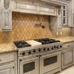 A spacious kitchen features a large stainless steel gas range with double ovens, granite countertops, a tan diamond-pattern backsplash, distressed wood cabinets, and a built-in microwave.