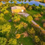 A building surrounded by trees and a river.